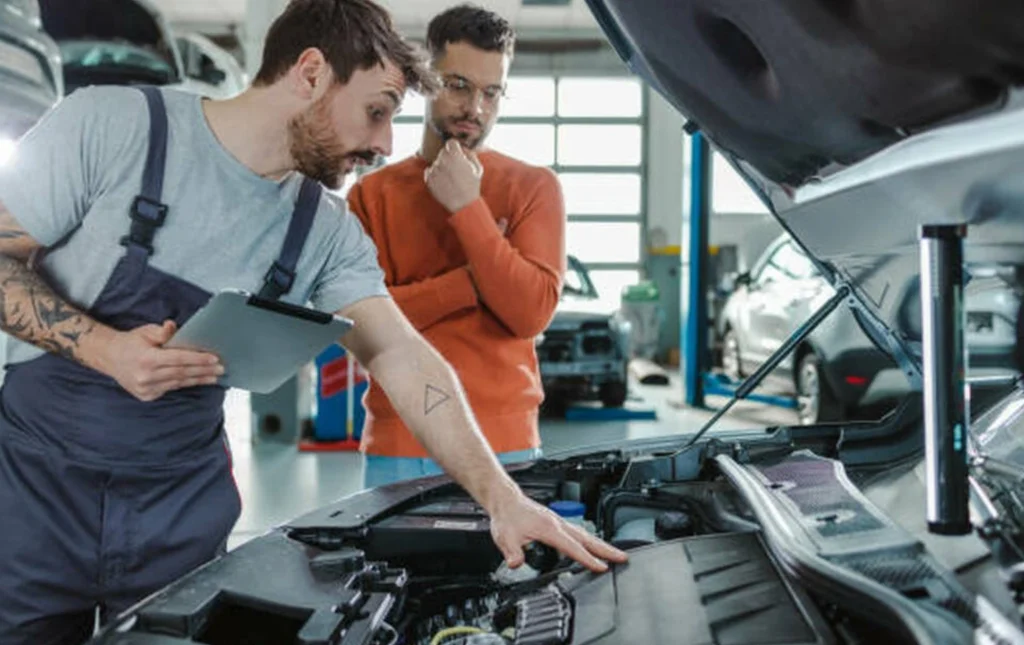 customer-and-automotive-technician-talking-about-the-car-problem-in-a-garage