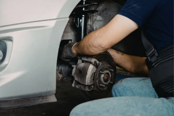 Mechanic-repairing-car-brake-What-Causes-MOT-Failure