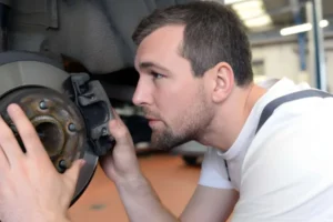 squeaky-brakes-technician-checking-car-brake-disc