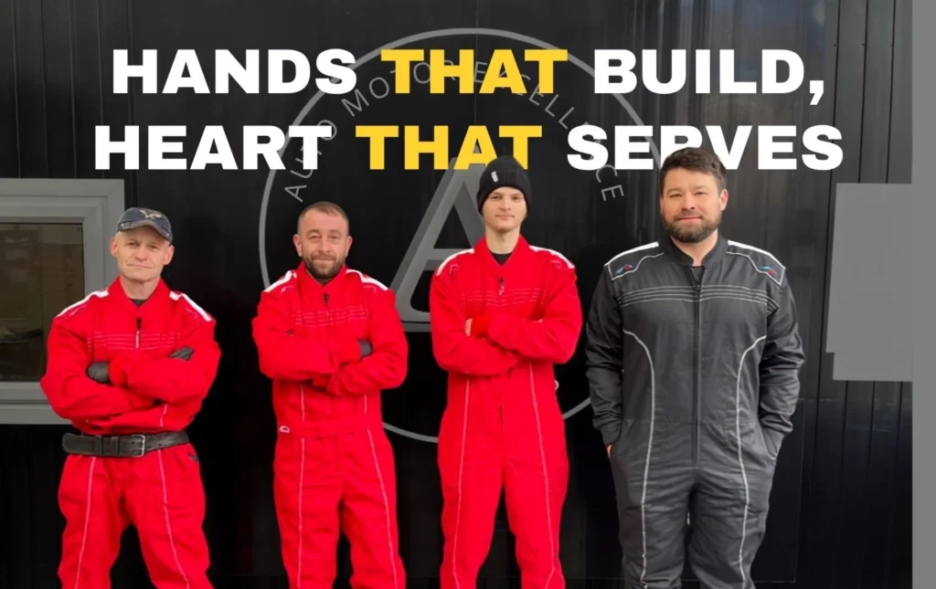 AutoNet-VIP-team-standing-together-outside-the-garage-wearing-red-and-black-work-overalls-with-the-text-Hands-That-Build-Heart-That-Serves-above-them