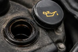 Engine-Oil-Light-warning-related-to-oil-condition-showing-an-open-oil-filler-cap-and-dirty-engine-oil-inspection-area